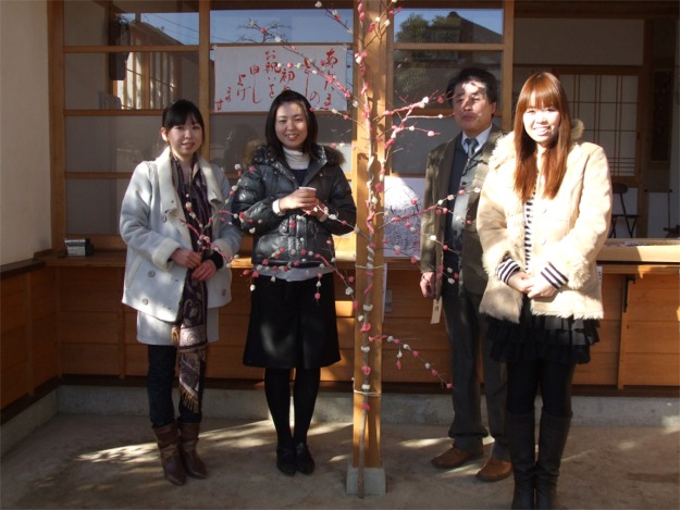参拝者による団子差しで出来上がった大きな春の花を囲んで親子の記念写真